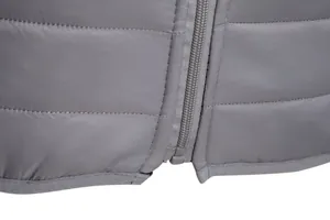 Close-up of durable zipper and high-quality quilting on men's gray winter puffer jacket.