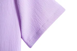 Close-up of purple casual shirt sleeve showing textured fabric and neat stitching.