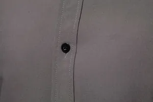 Detailed macro view of a grey casual shirt showcasing fine fabric texture and button
