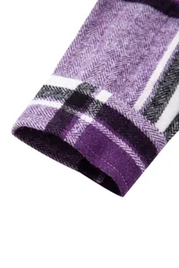 Primer plano detallado del puño de una camisa a cuadros morados con tejido espiga