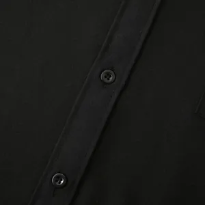 Detailed macro view showing the buttons and linen fabric texture of a black casual shirt