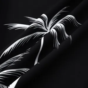 Gros plan sur le tissu à imprimé palmier noir et blanc d'une chemise hawaïenne pour homme
