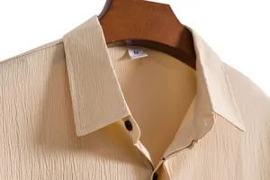 Macro view of textured fabric and collar on a beige men's short sleeve shirt