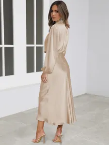 Elegant champagne satin long-sleeve midi dress featuring a high neck and cinched waistline.