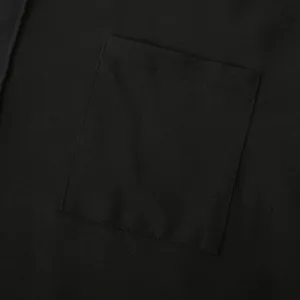 Close-up macro detail showing the stitching and texture of a black linen shirt pocket