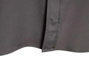 Macro view of dark grey men's casual shirt fabric texture and stitching detail at hem