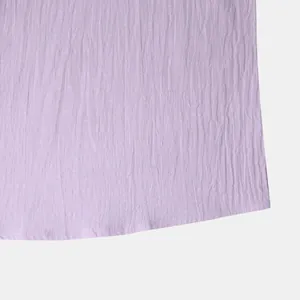 Close-up detail of the breathable purple cotton-linen fabric and hem of the casual men's shirt.