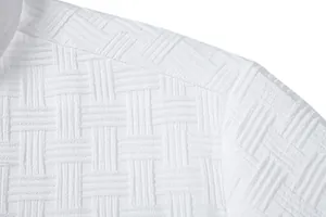 Macro view of white textured jacquard fabric on a men's ethnic style summer shirt detail.
