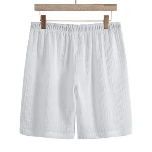 Detailed view of men's white jacquard shorts with textured fabric and elastic waist