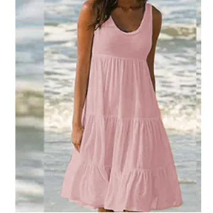 Elegantes rosa ärmelloses Strandkleid mit Rundhals und Stufenrock am sonnigen Meer gezeigt