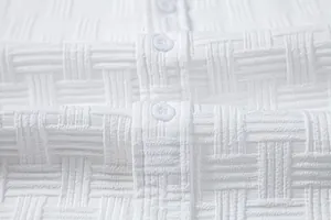 Close-up of white men's shirt with textured basket-weave pattern and buttons