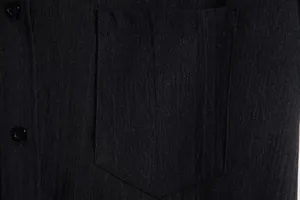 Close-up of chest pocket and textured fabric on men's black short sleeve shirt