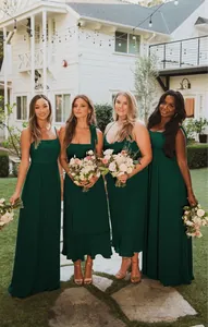 Elegant emerald green maxi dresses worn by four bridesmaids at an outdoor garden wedding.