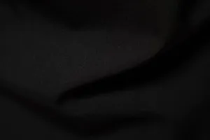 Macro texture detail of the premium black woven fabric used in men's casual beach shirts