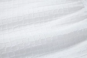 Close-up detail showing the intricate white jacquard fabric texture with waffle grid pattern