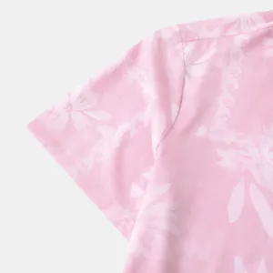 Detailopname van roze herenshirt met korte mouwen, bloemenprint en textuur van de stof.