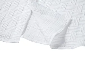 Macro detail of white textured fabric for men's ethnic style short sleeve shirt set.