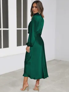 Elegant emerald green satin long-sleeved maxi dress showing side view silhouette