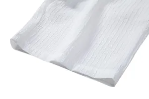 Detailed macro view of white jacquard fabric texture on the hem of a men's casual shirt