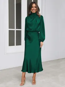 Deep green satin long-sleeved dress showing fabric sheen and elegant silhouette