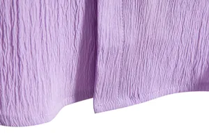 Close-up of purple textured fabric showing neat stitching on a men's summer shirt.