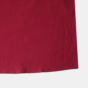 Detailed macro view showing red cotton linen fabric texture and hem stitching on men's shirt