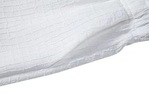 Close-up of white jacquard fabric texture and pocket detail of men's casual summer set.