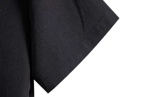 Close-up detail shot showing the fabric texture and hem of a men's black short sleeve shirt