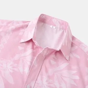 Detailopname van een roze herenoverhemd met bloemenprint, kraag, S-label en textuurstof.