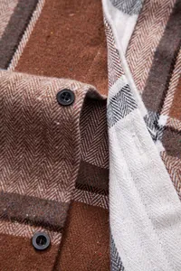 Primer plano de la textura de espiga y botones de una camisa de cuadros