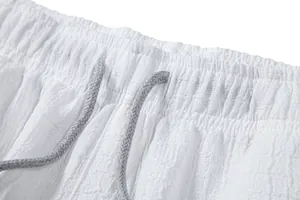 Detailed close-up of white jacquard shorts waistband featuring a grey adjustable drawstring