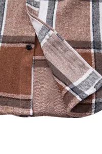 Detalle de camisa de franela a cuadros marrones con tejido de espiga y botón.