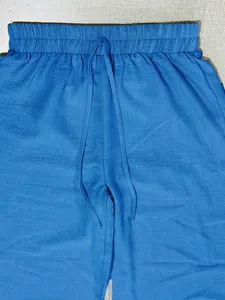 Detail of blue drawstring pants with elastic waistband for casual women's set.