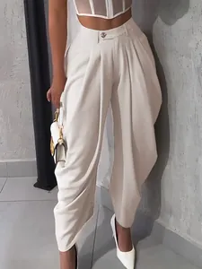 Detail shot of elegant off-white pleated high-waisted balloon trousers for women.