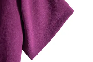 Close-up of purple textured fabric and hem stitching on men's short sleeve shirt