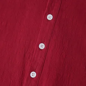 Close-up macro view of white buttons on a red cotton linen shirt showing fabric texture
