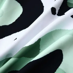 Gros plan d'un tissu léger avec imprimé floral abstrait vert et noir pour chemises