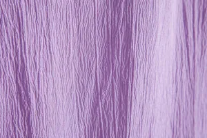 Detailed macro view showing the textured crinkled fabric of a light purple men's shirt