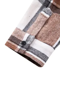 Primer plano de alta calidad del puño de una camisa a cuadros con botón negro y tejido