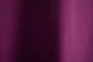 Macro view showing the detailed texture and rich purple color of a men's casual shirt.