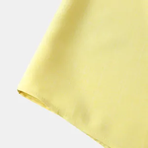 Primer plano detallado de la textura de lino amarillo en una camisa para hombre