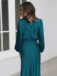 Detailed back view of an elegant teal satin long-sleeved evening gown for women.