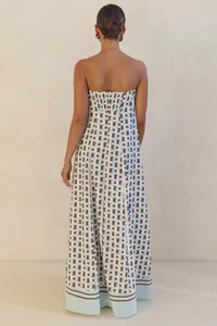 Rear view of a strapless maxi dress with a geometric blue and brown print.
