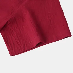 Close-up detail of dark red cotton linen shirt sleeve with neat stitched hem