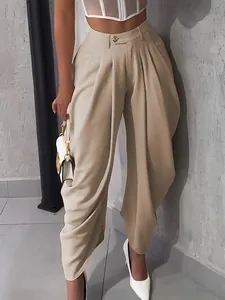 Detailed view of beige high-waisted pleated baggy trousers with a chic urban vibe