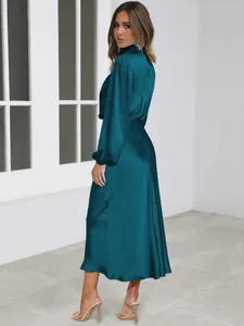 Detailed side view of an elegant teal satin long-sleeve midi dress with high neck design