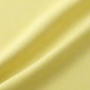 Vista macro que muestra la fina textura del tejido de camisa amarilla para hombre.