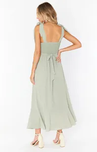 Back view of elegant sage green midi dress with tie shoulders and smocked bodice detail