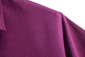 Close-up detail of the textured purple fabric on a men's casual short-sleeved shirt