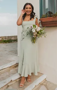 Elegant sage green sleeveless maxi dress featuring a side slit and ruffled hem detail